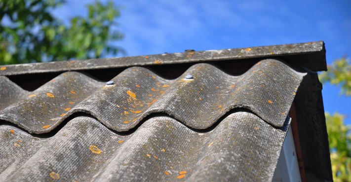 Blue sky over the dangerous asbestos old roof tiles