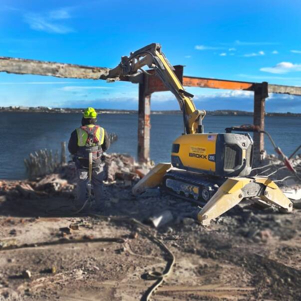 EnviroVantage Brokk operator and Brokk performing demolition on pier